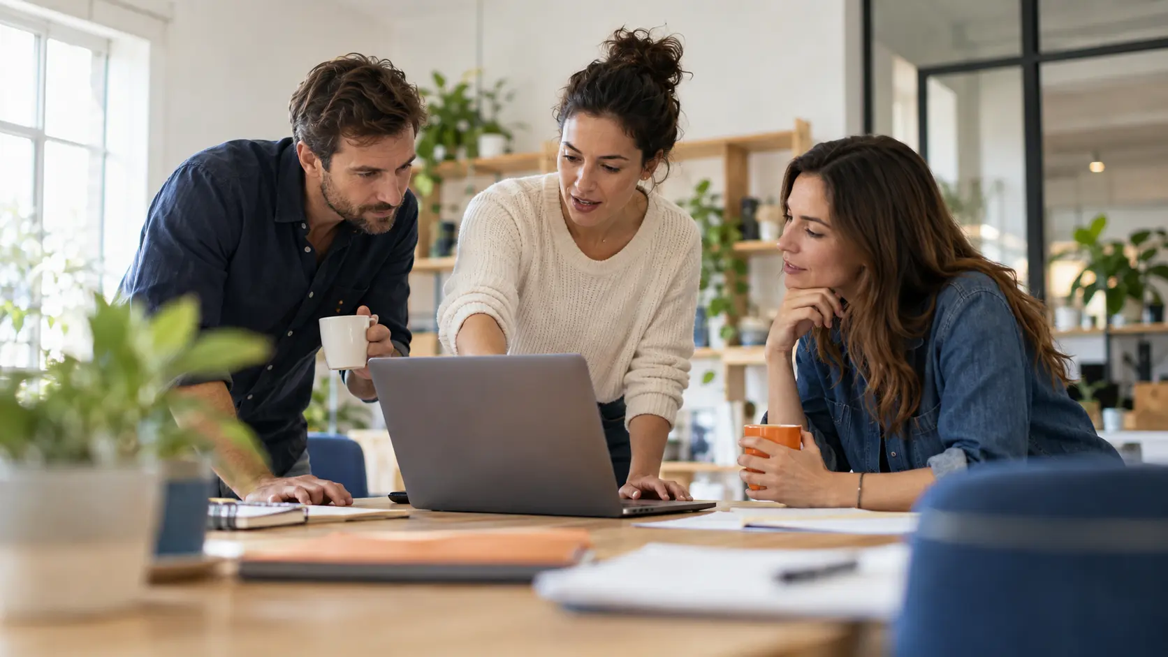 Trois collègues d'une petite entreprise font le point autour d'un ordinateur portable